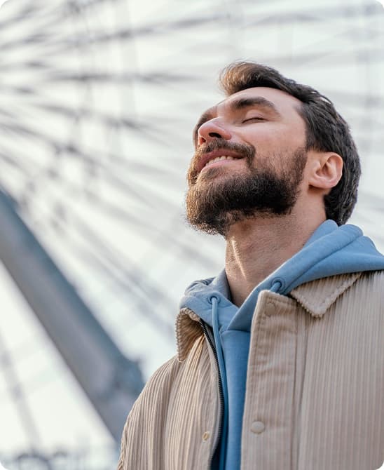 Man looking up with eyes closed, feeling at peace